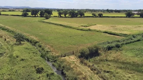 Aerial view, fly down move. plains and water stream on fields. Stock Footage 93485549