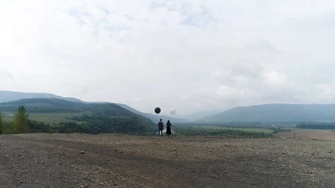 Aerial view. Fly towards a couple dressed in retro clothes and standing with Stock Footage 101790218