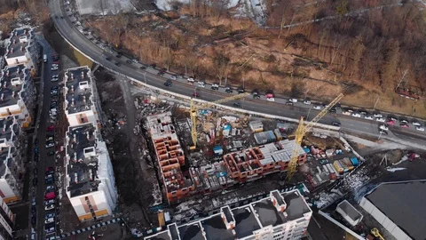 Aerial view Flying above a block under construction next to the highway Stock Footage 103785111