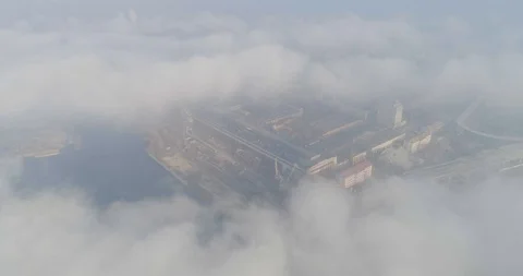 Aerial view flying above the clouds above the industrial zone of the city Video stock 107073044