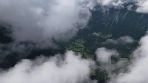 Aerial view flying above the clouds over a green valley Stock Footage 317719612