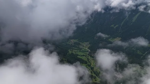 Aerial view flying above the clouds over a green mountain valley Stock Footage 317719731