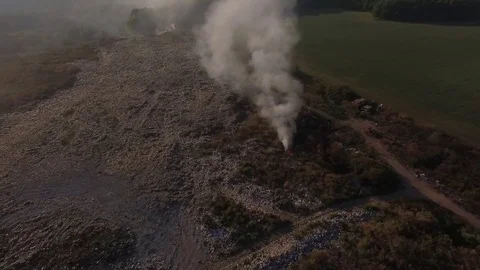 Aerial view. Flying around illegal garbage dump that smokes Stock Footage 71378295