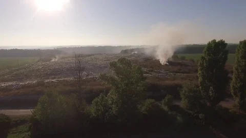 Aerial view. Flying around illegal garbage dump that smokes Stock Footage 71378330