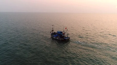 Aerial view. Flying around a small fishing vessel at sunset over the sea.  스톡 동영상 104667629