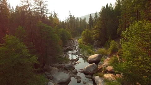 Aerial view flying backwards over creek in the Sierra National Forest California Video stock 89351965