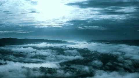 Aerial view, flying backwards over a tropical forest covered in fog Stock Footage 165834839