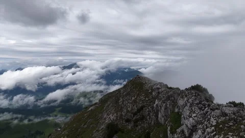 Aerial view flying backwards over a rugged mountain ridge revealing a valley Stock Footage 319051577