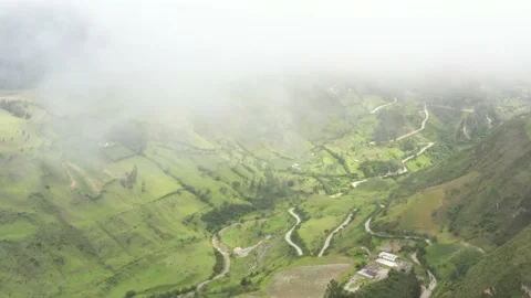 Aerial view flying between the clouds over a in grass covered green valley Stock Footage 142752716