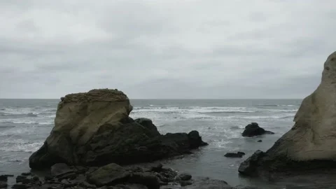 Aerial view flying between the rocky outcrops into the open pacific ocean Stock Footage 146754505