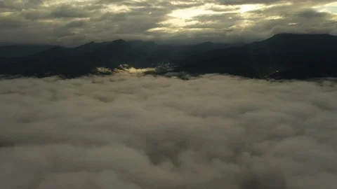 Aerial view flying in the clouds when the sunrise on the mountain Stock Footage 116609832