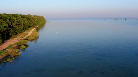 Aerial view flying down a lake shoreline Stock Footage 66523341