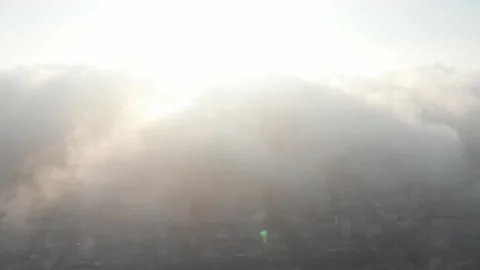 Aerial view flying down through thick clouds over the city Stock Footage 158088115