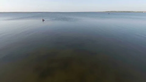 Aerial view from flying drone of a man is fishing, at sea Stock Footage 85175511