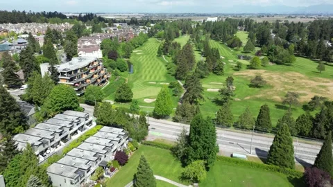Aerial view flying forward over townhouses and golf green tilting up to reveal Stock Footage 337743479