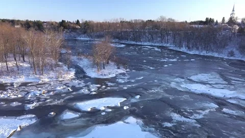 Aerial view flying from left to right over the frozen river showing small i.. 動画素材 235832782