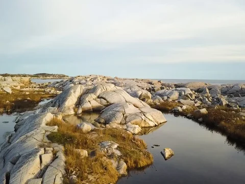 Aerial view flying low over rocks as the sun sets in Nova Scotia Stock Footage 82511447