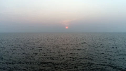 Aerial view. Flying low over the waves of the sea at sunset.  Video stock 104664741