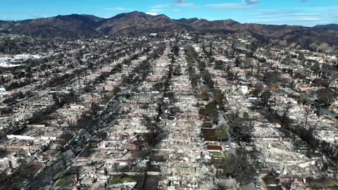 Aerial view flying over the burned Pacific Palisades area, fire aftermath in LA Stock Footage 301063064