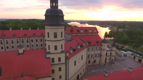 Aerial View. Flying over the castle's old town at sunset with sun rays. Stock Footage 64028691