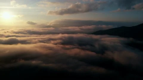Aerial view: Flying Over Clouds on Sun Rise in Mountains. Stock Footage 162829896