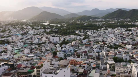 Aerial view flying over dense asian cityscape with mountains Stock Footage 344290906