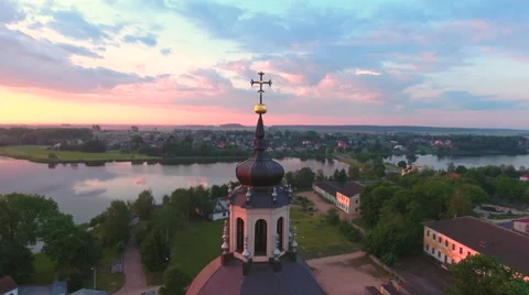 Aerial View. Flying over the dome of the church with a cross in the city at suns Stock Footage 63833855