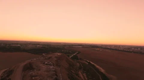Aerial View. Flying over a dump in the middle of a field at sunset. Stock Footage 67997953