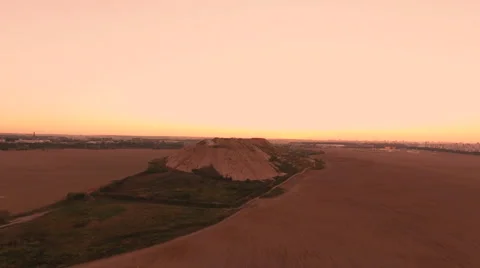 Aerial View. Flying over a dump in the middle of a field at sunset. Stock Footage 67998089