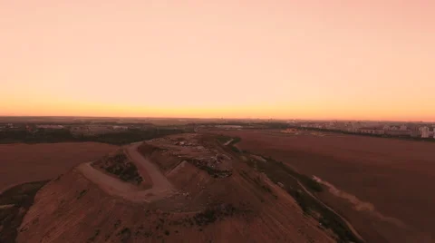 Aerial View. Flying over a dump in the middle of a field at sunset. Stock Footage 67998452