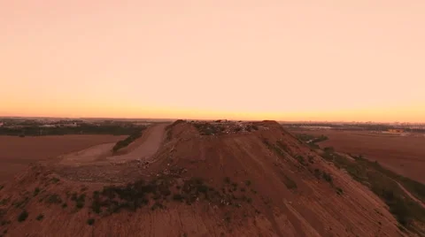 Aerial View. Flying over a dump in the middle of a field at sunset. Stock Footage 67998555