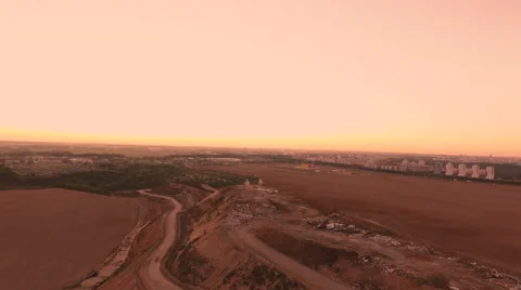 Aerial View. Flying over a dump in the middle of a field at sunset. Stockbeeldmateriaal 67998716