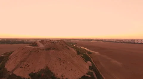 Aerial View. Flying over a dump in the middle of a field at sunset. Stock Footage 67998720