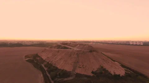 Aerial View. Flying over a dump in the middle of a field at sunset. Stock Footage 68000174