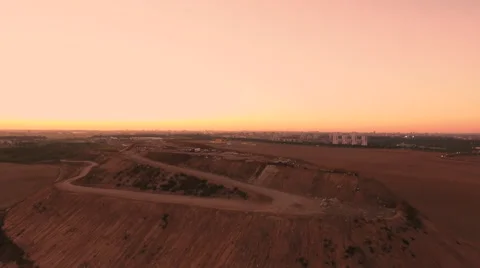 Aerial View. Flying over a dump in the middle of a field at sunset. Stock Footage 68000181