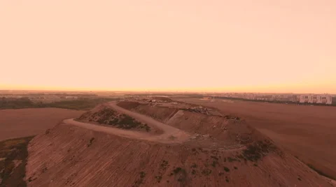 Aerial View. Flying over a dump in the middle of a field at sunset. Stock Footage 68000268
