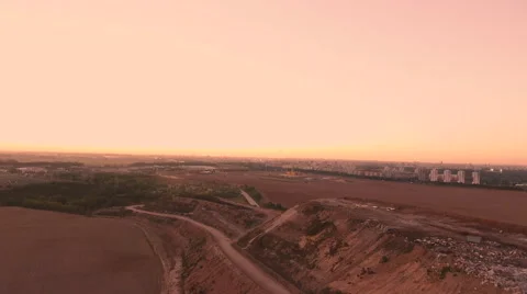 Aerial View. Flying over a dump in the middle of a field at sunset. Stock Footage 68000327