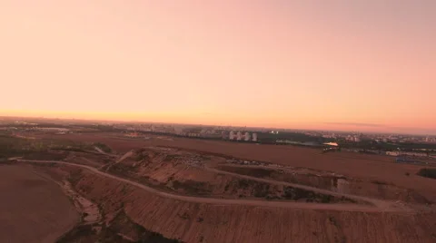 Aerial View. Flying over a dump in the middle of a field at sunset. Stock Footage 68000965