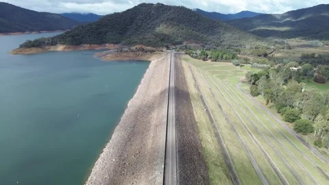 Aerial view flying over eildon dam wall Stock Footage 334906983