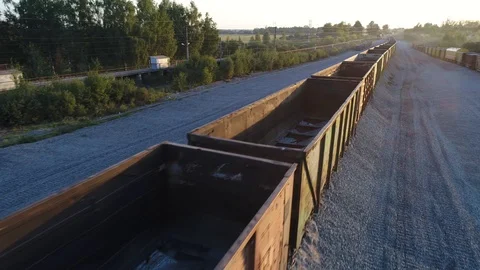 Aerial view. Flying over empty railroad cars for gravel on the rails at sunset. Vídeos de archivo 94496492
