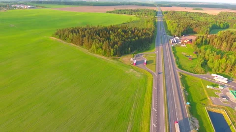 Aerial View. Flying over the green sown field along the road with cars. 스톡 동영상 63781474