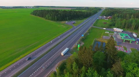 Aerial View. Flying over the green sown field along the road with cars. Stock Footage 63782152