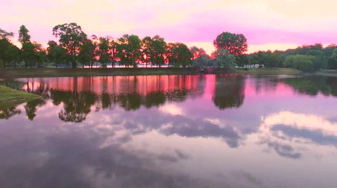 Aerial View. Flying over the green trees above the river at dawn with Stock Footage 63824257