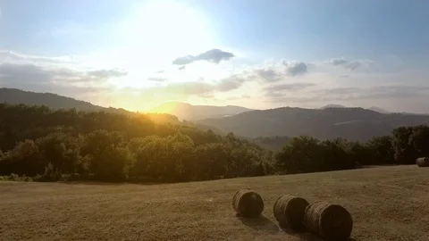 Aerial view flying over hay bales in a rural field at sunset at evening Stock-Footage 97981253