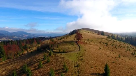 Aerial View. Flying over the high autumn mountains in beautiful clouds . Aerial Stock Footage 83129150