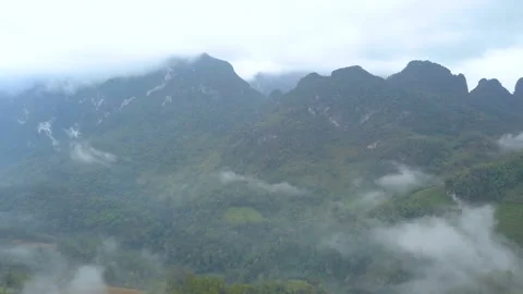 Aerial View. Flying over the high mountains forest with beautiful clouds fog, at Stock Footage 162669740
