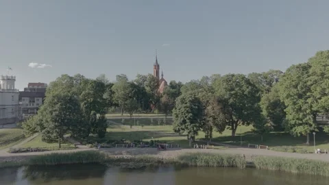 Aerial View Flying Over Lake Towards Red Brick Church Surrounded by Trees Stock Footage 342202601