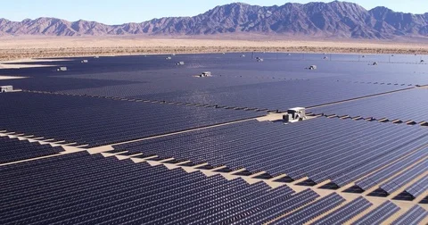 Aerial view flying over large industrial solar energy farm in desert Stock Footage 81690854
