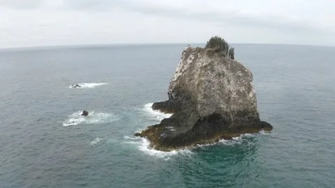 Aerial view flying over a large and high rock outcrop Stock Footage 146755470