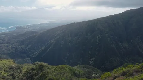 Aerial view flying over lush green misty mountain peaks in Maui, Hawaii Stock Footage 276811043